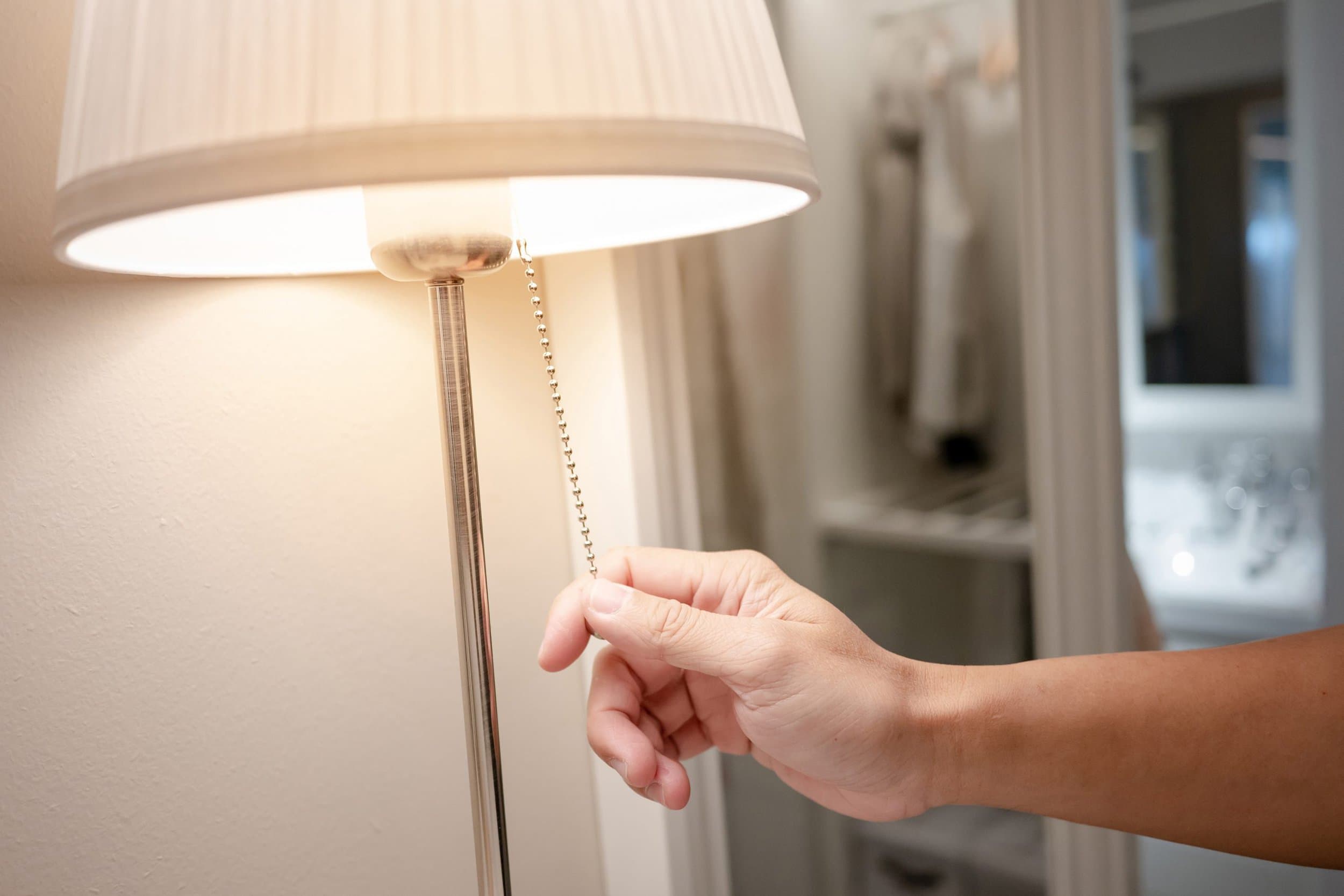 lighting-conservation man turning on floor lamp